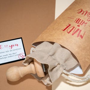 May include: A package with a wooden stamp, a small drawstring bag, and a thank you card. The brown paper bag is printed with "MADE WITH LOVE" in red. The thank you card reads "Thank you for supporting my business!"