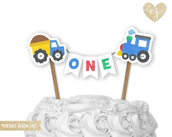 May include: Printable cake topper featuring a blue train, a yellow dump truck, and a banner that says "ONE" in colorful letters. The topper is perfect for a first birthday party.