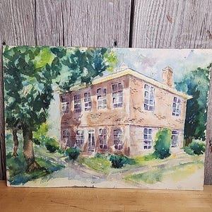 May include: Watercolor painting of a brick building with a green roof and windows. The building is surrounded by green trees and grass.