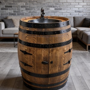 Peut inclure: Un évier en forme de tonneau en bois rustique avec un robinet et un bassin en métal noir. Le tonneau a des bandes et des charnières en métal noir, et une petite porte de placard. L'évier est placé contre un mur de briques grises.