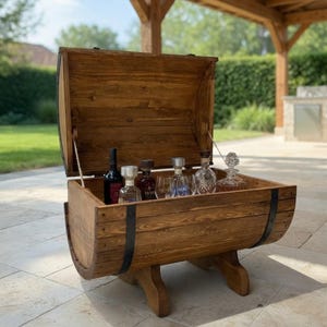 Peut inclure: Un coffre en bois brun en forme de tonneau avec un couvercle à charnière, doté de bandes métalliques noires et d'une base solide. L'intérieur contient plusieurs bouteilles en verre et une carafe, offrant un rangement pour les boissons.