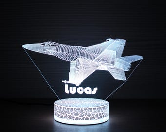 May include: A white 3D printed night light shaped like a fighter jet with the name "Lucas" printed below. The night light is on a white base with a textured surface.