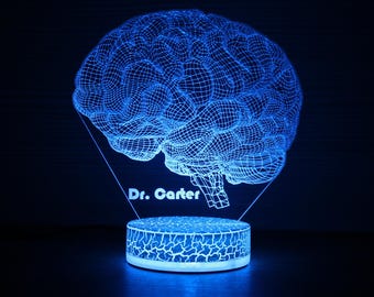 May include: A blue 3D printed brain shaped night light with the text "Dr. Carter" on the base.