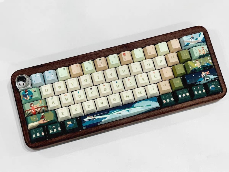 K&ouml;nnte beinhalten: Eine benutzerdefinierte Tastatur mit einem Holzrahmen und einer Vielzahl von Tastenkappen mit verschiedenen Farben und Designs. Die Tastenkappen haben ein hellblaues, gr&uuml;nes und wei&szlig;es Farbschema mit Illustrationen von Blumen, B&auml;umen und anderen naturinspirierten Elementen. Die Tastatur hat auch eine benutzerdefinierte Leertaste mit einem blauen und gr&uuml;nen Design.