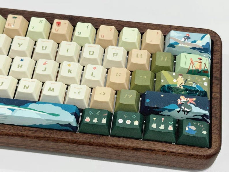 K&ouml;nnte beinhalten: Eine benutzerdefinierte Tastatur mit einem Holzrahmen und Tastenkappen mit verschiedenen Illustrationen. Die Tastenkappen haben ein hellbraunes, gr&uuml;nes und blaues Farbschema. Die Illustrationen umfassen eine Waldszene, einen Nachthimmel mit Sternen und eine Szene mit einem Vogel und einer Person.