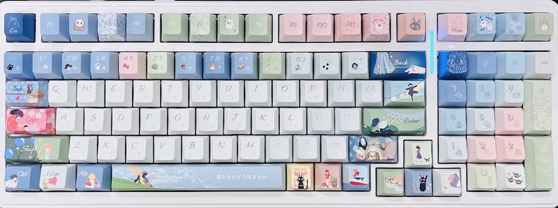May include: A white mechanical keyboard with custom keycaps featuring various pastel colors and illustrations. The keycaps have designs of flowers, animals, and other whimsical imagery. The keyboard has a white frame and a black space bar.