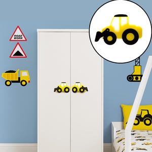 May include: Yellow construction-themed wall decorations, including a dump truck, road signs, and a tractor. Two tractor-shaped cabinet knobs are on a white wardrobe. A yellow pillow with a tractor design is on a bed.