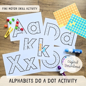 May include: Educational activity set featuring alphabet letters with dot outlines. Includes colorful pom-poms, tweezers, dot stickers, and markers. The text reads "FINE MOTOR SKILL ACTIVITY" and "ALPHABETS DO A DOT ACTIVITY".