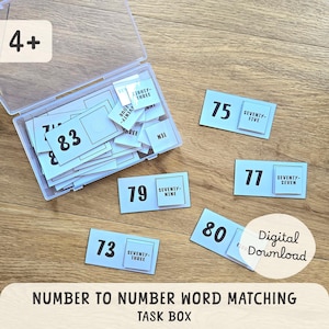 May include: A clear plastic box filled with white number cards, some scattered on a wooden surface. The cards display numbers like 73, 75, 77, 79, 80, and 83, along with their corresponding word forms. The text "NUMBER TO NUMBER WORD MATCHING TASK BOX" is at the bottom.
