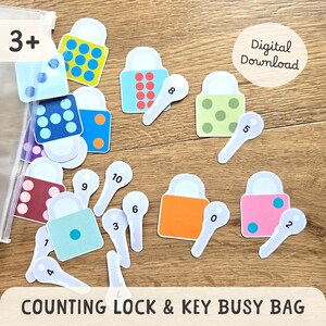 Peut inclure: Ensemble de cadenas et de clés de comptage colorés. Les cadenas sont de différentes couleurs, avec des motifs variés. Chaque clé porte un numéro de 0 à 10. Le texte "COUNTING LOCK & KEY BUSY BAG" est visible en bas.