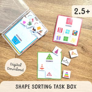 Peut inclure: Une boîte de tri de formes avec des cartes et de petits carreaux. Les cartes présentent des formes telles qu'un carré, un triangle et un trapèze, avec des images correspondantes. La boîte est étiquetée "Téléchargement numérique" et "2.5+".