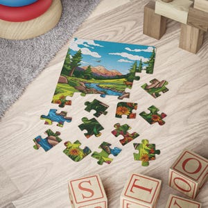 May include: A partially assembled jigsaw puzzle depicting a scenic landscape with a river, mountains, and trees. Several puzzle pieces are scattered around, along with wooden blocks and a colorful stacking toy. The puzzle features vibrant colors.