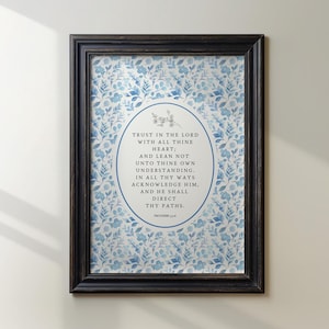May include: A framed print with a floral design in blue and white. The print has an oval centre with the text "TRUST IN THE LORD WITH ALL THINE HEART;" and other inspirational text. The frame is dark brown.