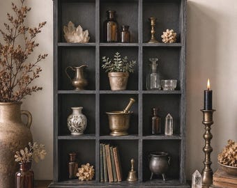 Vitrina de pared tipo caja de madera negra con 12 compartimentos, estilo rústico.