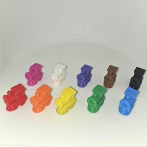 May include: Ten colorful toy train engine pieces in various colors including red, orange, yellow, green, blue, purple, white, brown, and black.