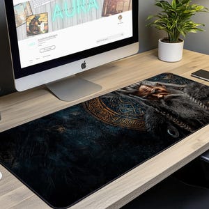 May include: A dark blue and gold mousepad with a detailed image of a bearded man's face. The man's face is surrounded by a gold and black design.