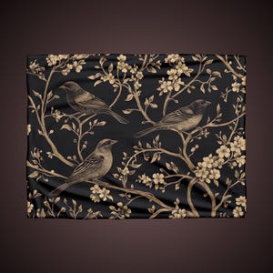 May include: Black fabric with a gold floral pattern and three birds. The birds are drawn in a vintage style and are perched on the branches of the flowers.