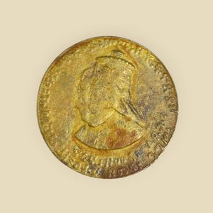 May include: A gold-colored coin with a profile of a woman wearing a crown. The coin has the inscription "VICTORIA REGINA 1837 - 1901" around the edge.