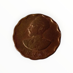May include: A copper-colored coin with a profile of a person on one side and the text "1 បាត" on the other side.