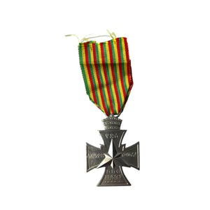 Puede incluir: Una medalla de plata con un dise&ntilde;o de cruz y una estrella en el centro. La medalla tiene los a&ntilde;os 1914-1918 y 1939-1945 inscritos en ella. La medalla est&aacute; unida a una cinta de rayas verdes, amarillas y rojas.