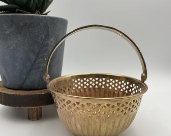 Cesta vintage de latón macizo con asa móvil, redonda y diseño recortado.