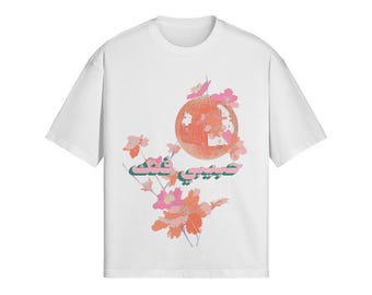 May include: White t-shirt with a graphic design featuring a pink and orange globe with a green and white text overlay. The text reads "عالمیبت"