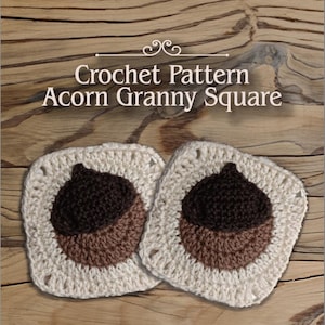 Op de afbeelding: Twee gehaakte eikel oma-vierkanten in beige, bruin en donkerbruin. De vierkanten liggen op een houten oppervlak met herfstbladeren.