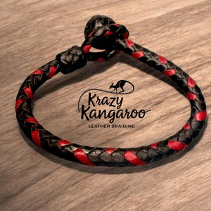 May include: Braided leather bracelet in black and red. The bracelet features a woven design with alternating black and red leather strands. The text "Krazy Kangaroo Leather Braiding" is visible on the bracelet.