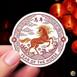 Close-up of a circular vinyl sticker featuring a red and gold ornate horse in a rearing pose, symbolizing the Chinese zodiac Year of the Horse. The design includes traditional clouds and waves, with the text "YEAR OF THE HORSE" and Chinese characters. Perfect for Lunar New Year 2026.