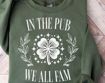 Puede incluir: Sudadera verde con un diseño de trébol blanco y el texto "In the Pub We All Fam".
