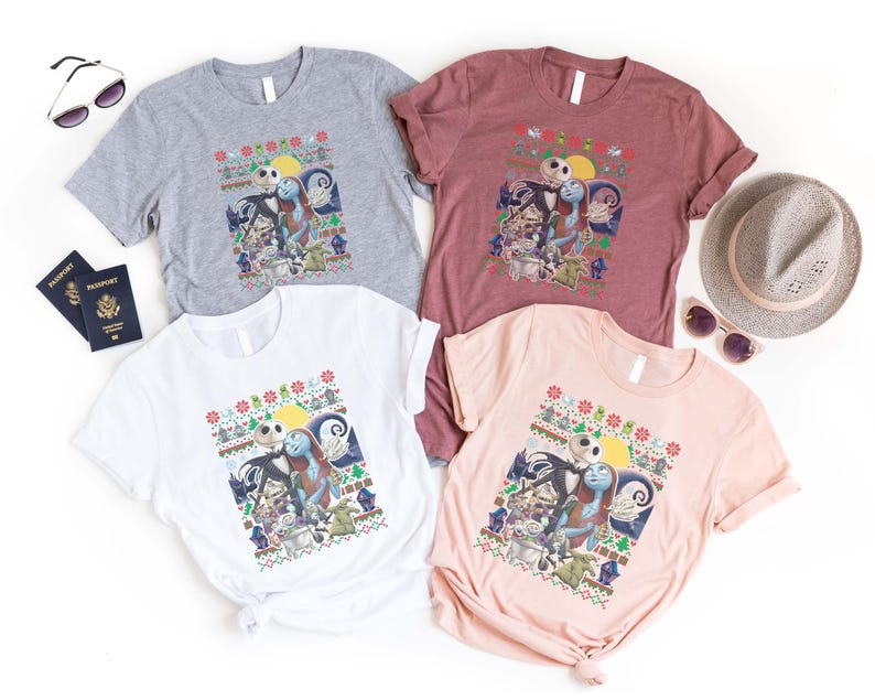 May include: Four t-shirts featuring a Christmas-themed design with Jack Skellington and Sally from The Nightmare Before Christmas. The shirts are in grey, maroon, white, and pink.