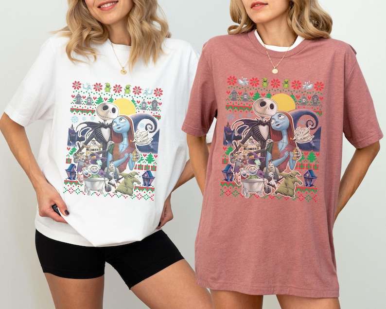 May include: White and pink t-shirts with a Christmas-themed graphic featuring Jack Skellington and Sally from The Nightmare Before Christmas. The graphic includes a moon, stars, and a Christmas tree.