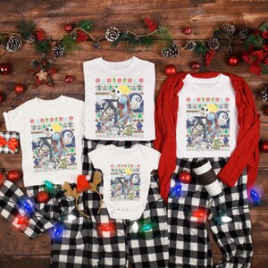 May include: A family matching set of white t-shirts with a Christmas themed design featuring Jack Skellington and Sally from the Nightmare Before Christmas. The shirts have a red and green plaid pattern and are laid out on a wooden surface with Christmas decorations.