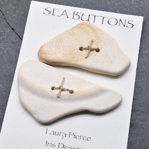 White fish    two  large naturally ocean smoothed sea pottery buttons from Maine