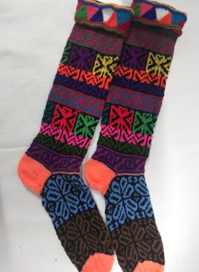 May include: A pair of colorful knitted knee-high socks with geometric patterns in shades of pink, blue, green, yellow, and black.