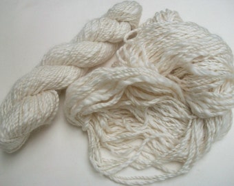 May include: Two skeins of white yarn, one is a twisted rope style and the other is a fluffy, loose style.