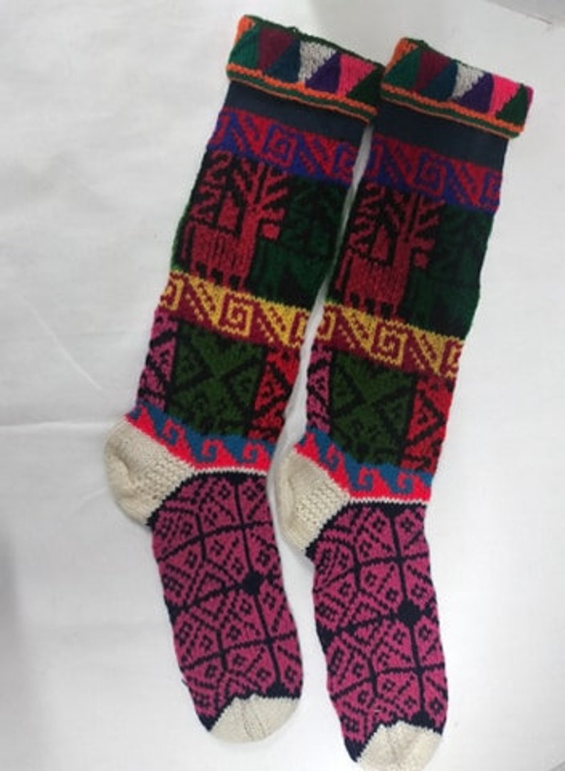May include: A pair of colorful knitted knee-high socks with geometric and animal patterns. The socks are made of wool and have a white cuff.