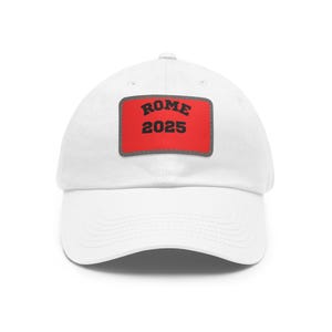 May include: White baseball cap with a red patch that says "ROME 2025" in black text.