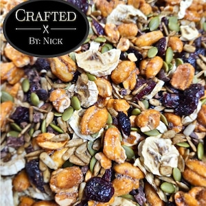 Puede incluir: Primer plano de una mezcla de granola con varios ingredientes. La granola incluye nueces, semillas, frutas secas y otros componentes. La imagen tiene un óvalo negro con el texto "Crafted by Nick".