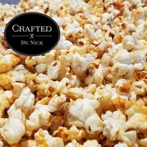 May include: Close-up of a bowl of popcorn. The popcorn is white and yellow and appears to be lightly buttered. The text "CRAFTED X BY: NICK" is visible in the upper left corner of the image.