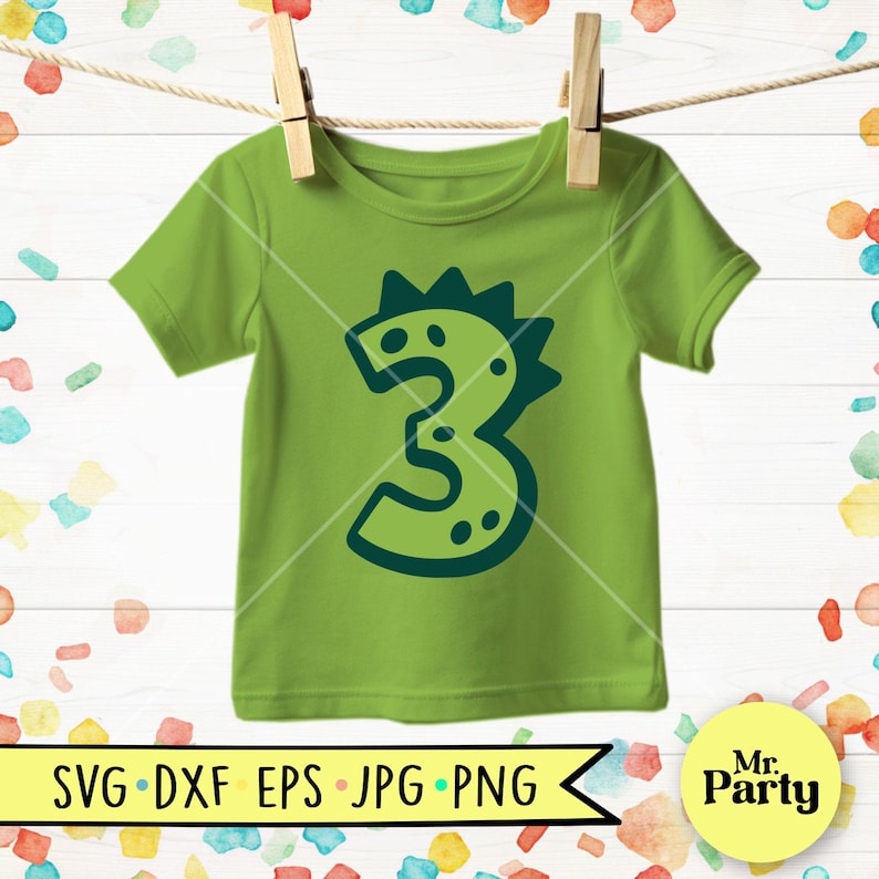 Pu&ograve; includere: Una maglietta verde lime per bambini con un disegno del numero 3 verde scuro. Il numero 3 ha l'aspetto di un dinosauro con punte e punti. La maglietta &egrave; appesa a un filo per stendere con mollette di legno. La parte inferiore dell'immagine contiene il testo "SVG DXF EPS JPG PNG".