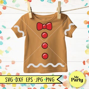 May include: A tan t-shirt with a gingerbread man design, featuring a red bow tie and buttons, and white icing details. The shirt is hanging from a clothesline with wooden clothespins. The bottom of the shirt has the text "SVG DXF EPS JPG PNG".