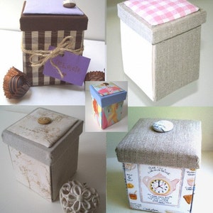 May include: Four different fabric-covered boxes with various designs. The boxes are square and have a lid. The designs include a brown and white plaid, a pink and white gingham, a floral pattern, and a teacup and clock design.