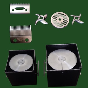 Pode incluir: Uma coleção de peças de moedor de carne em aço inoxidável, incluindo lâminas, placas de corte e um conjunto de lâminas. Também estão presentes dois recipientes pretos com componentes circulares prateados. A imagem está em um fundo verde escuro.