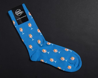 May include: Blue socks with a pattern of orange cocktails. The socks have a tag that says "Love & Victory" and "www.loveandvictorystore.com".