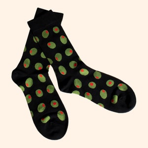 May include: A pair of black socks with a green and red olive pattern.