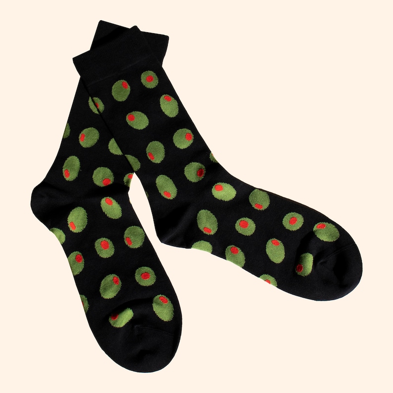 May include: A pair of black socks with a green and red olive pattern.