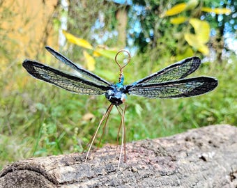 虹色に輝く黒いトンボ。手描きのオーナメントで、ガラスの目が付いてい