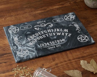 May include: Black and white Ouija board with a swirling marble pattern. The board features the letters of the alphabet, numbers 0-9, and the words "Ouija", "Yes", "No", and "Good Bye".