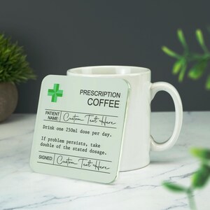 Puede incluir: Un posavasos de vidrio verde y blanco con una etiqueta de receta que dice "Prescription Coffee". La etiqueta incluye el texto "Custom Text Here" en dos lugares, y el texto "Drink one 250ml dose per day. If problem persists, take double of the stated dosage."